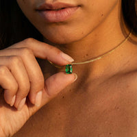 Thumbnail for Emerald Pendant Necklace worn by a model, featuring a vibrant green emerald in a gold setting by Brother & Sisters.