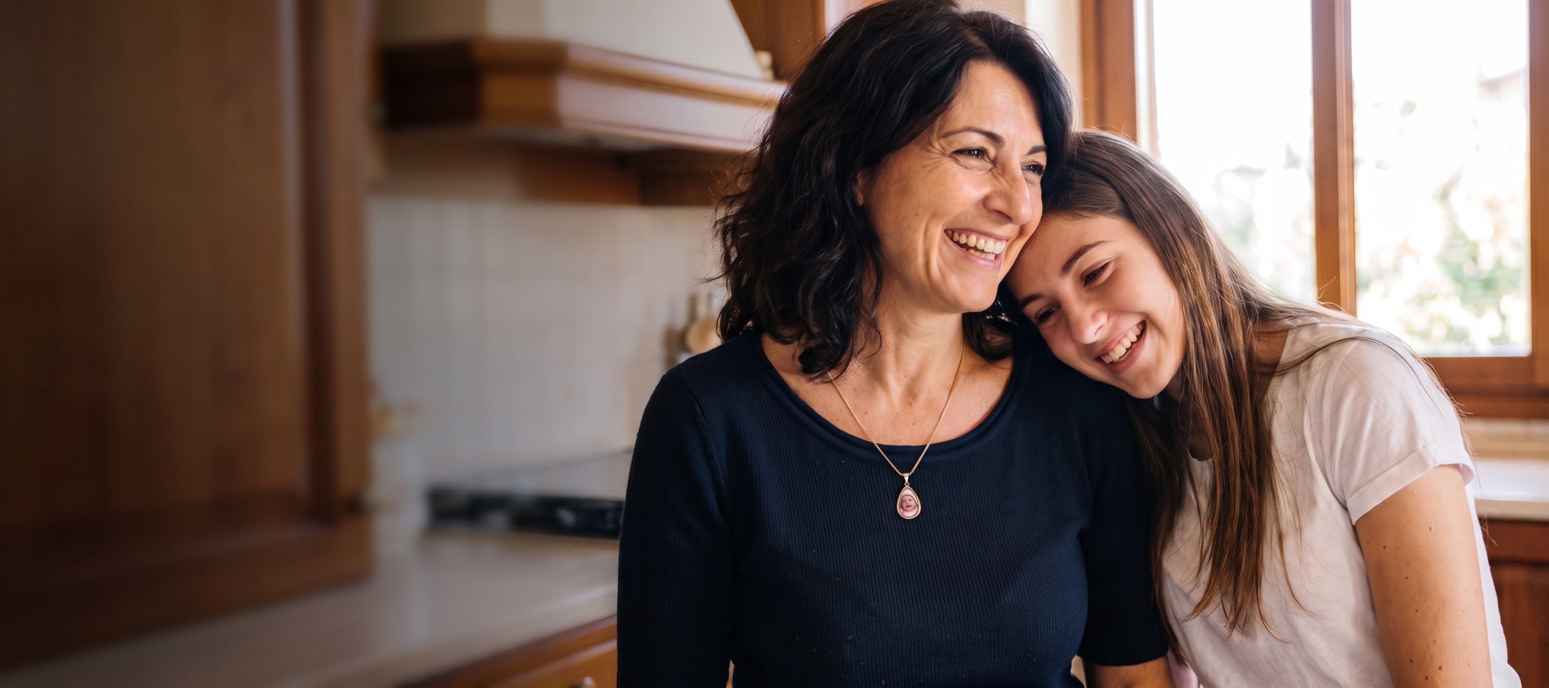 Mother and daughter laughing, mother wearing a Secret Photo Necklace