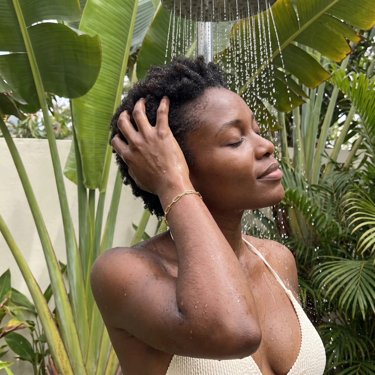 The Original bracelet in gold worn in an outdoor shower | SKU: l-original