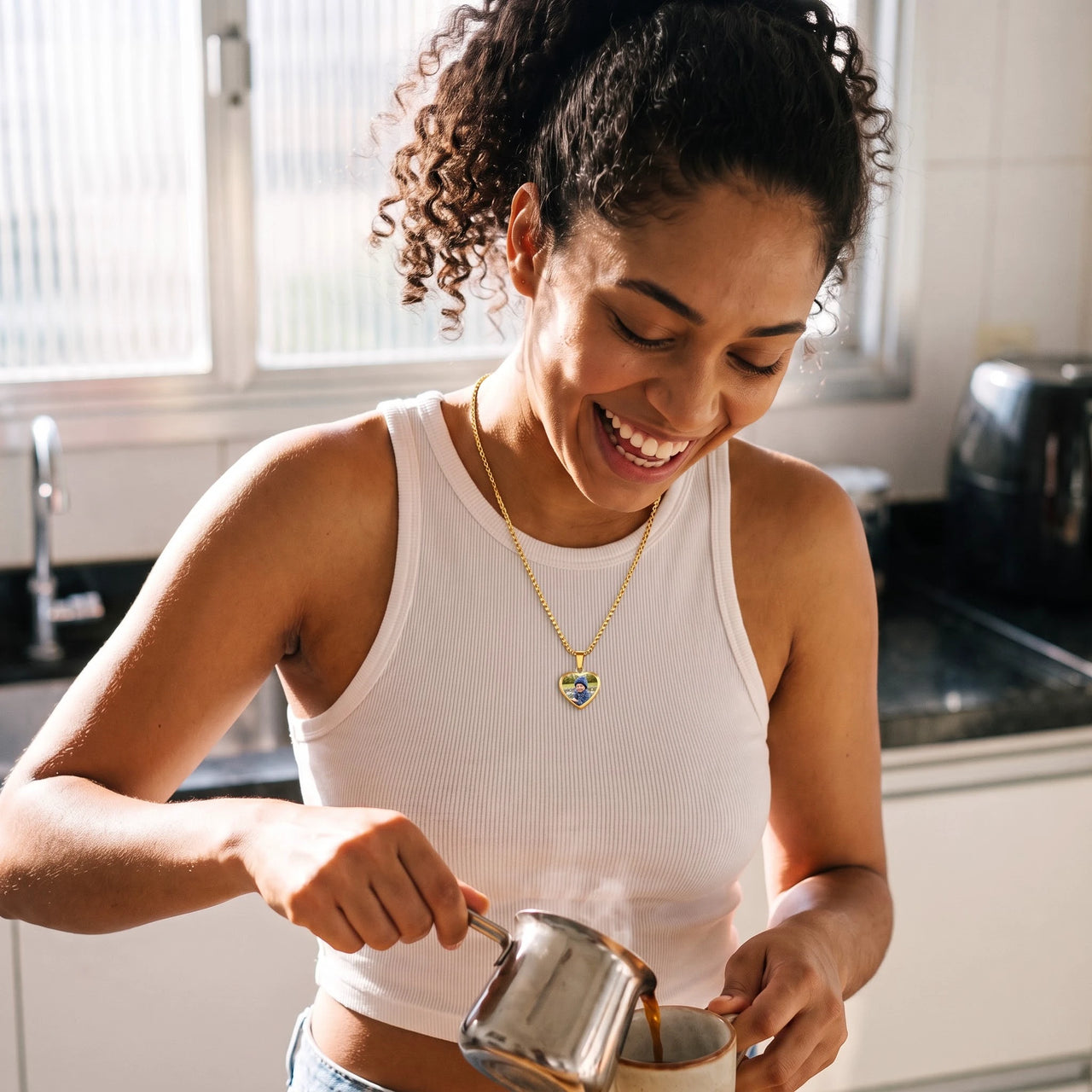 Woman laughing in her kitchen, wearing the gold secret heart photo necklace | SKU: TPH-CHTN-GOLD-SMALL