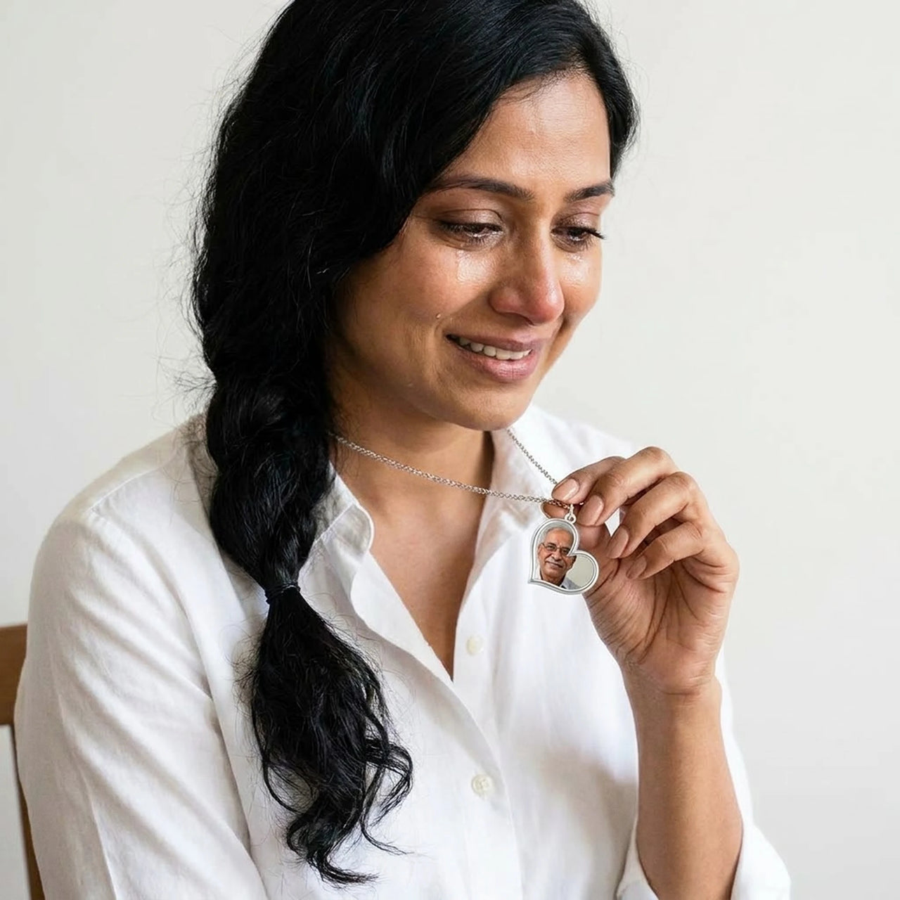 Woman moved as she looks at her late father's photo in the silver heart necklace | SKU: TPH-HRTN-SILVER