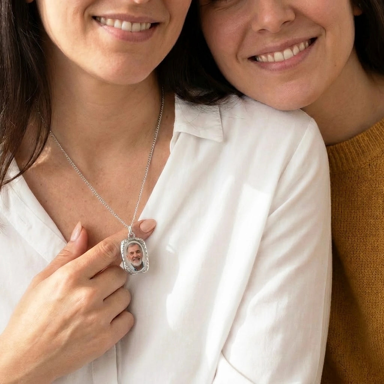 Sister fastening the silver oval photo necklace with their late father's photo | SKU: TPH-OVLN-SILVER
