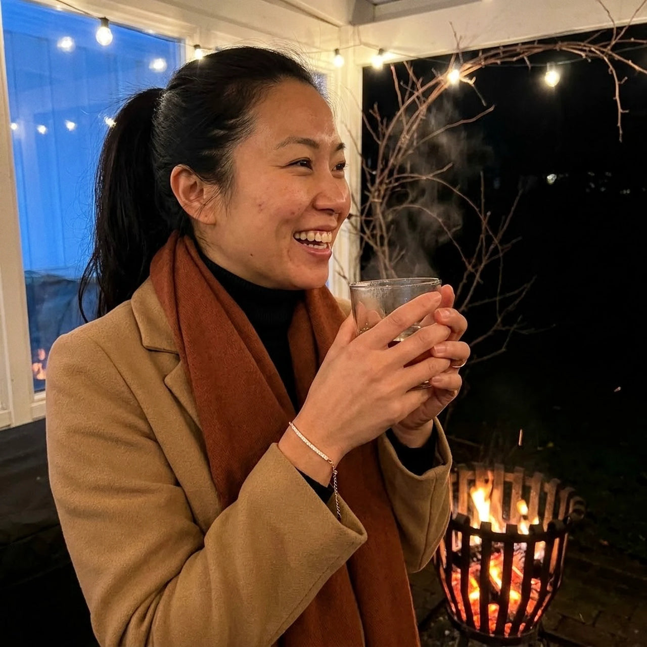 Femme portant le Crystal Bar Bracelet sur une terrasse d'hiver pres d'un brasero
